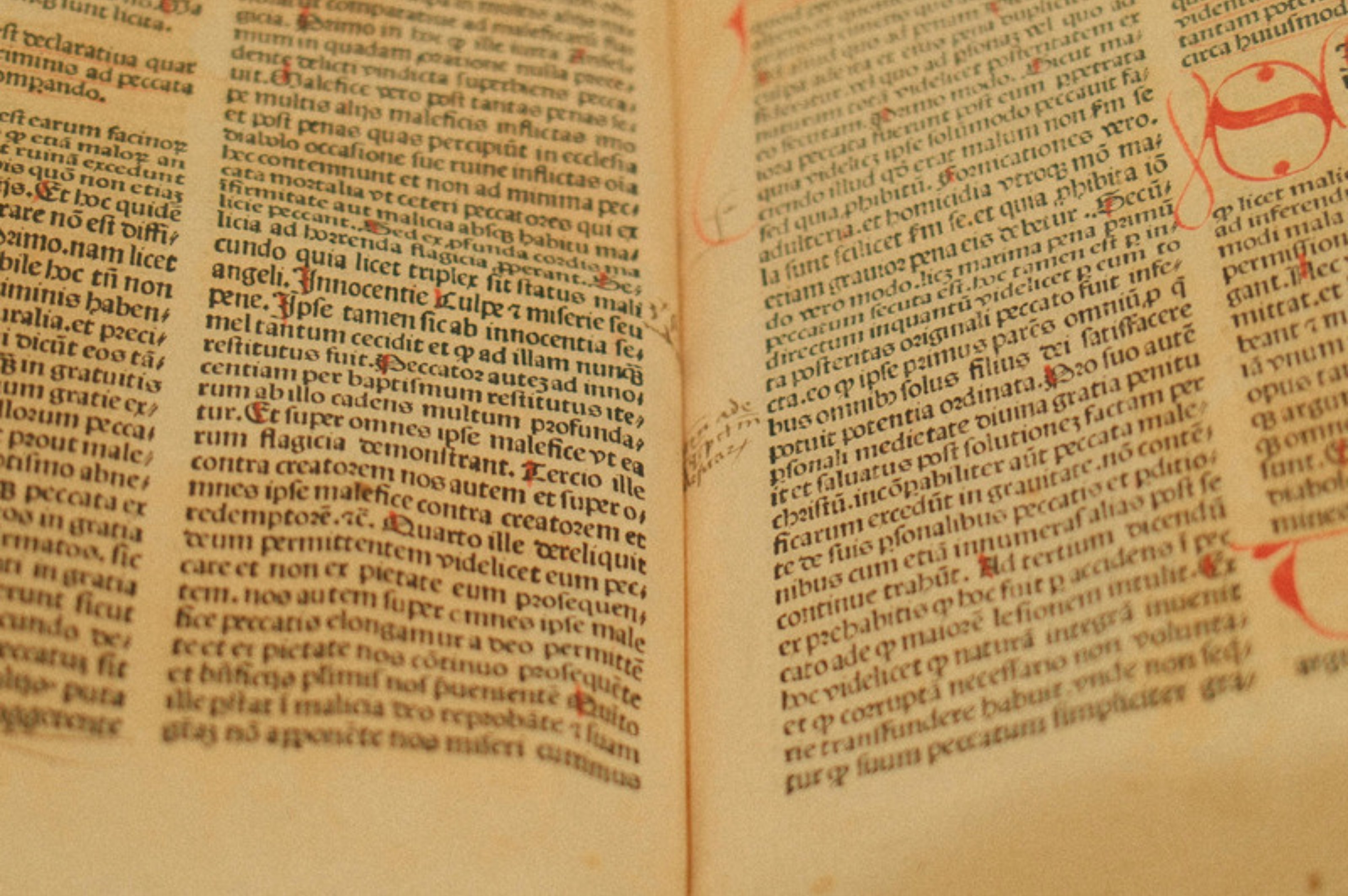 An open incunable book, with dense Latin text and red rubricated initials.